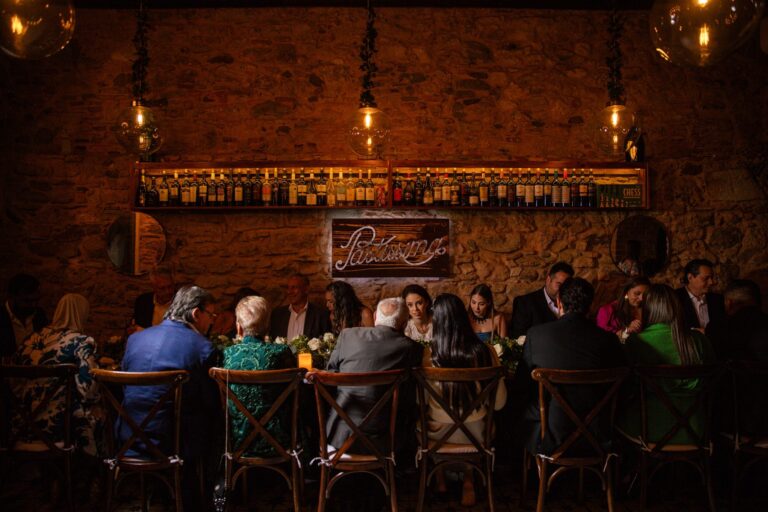 Cena de celebración en mesa imperial frente a la pared de piedra de Pastissima Casco Antiguo