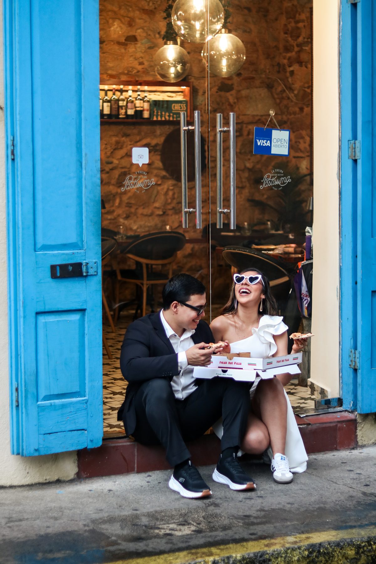 Novios comiendo pizza en la puerta azul de Pastissima Casco Antiguo