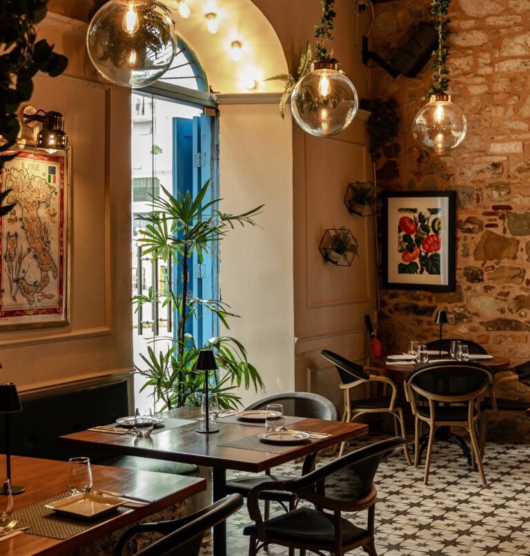 Salón con puerta azul y lámparas de vidrio en Pastissima Casco Antiguo