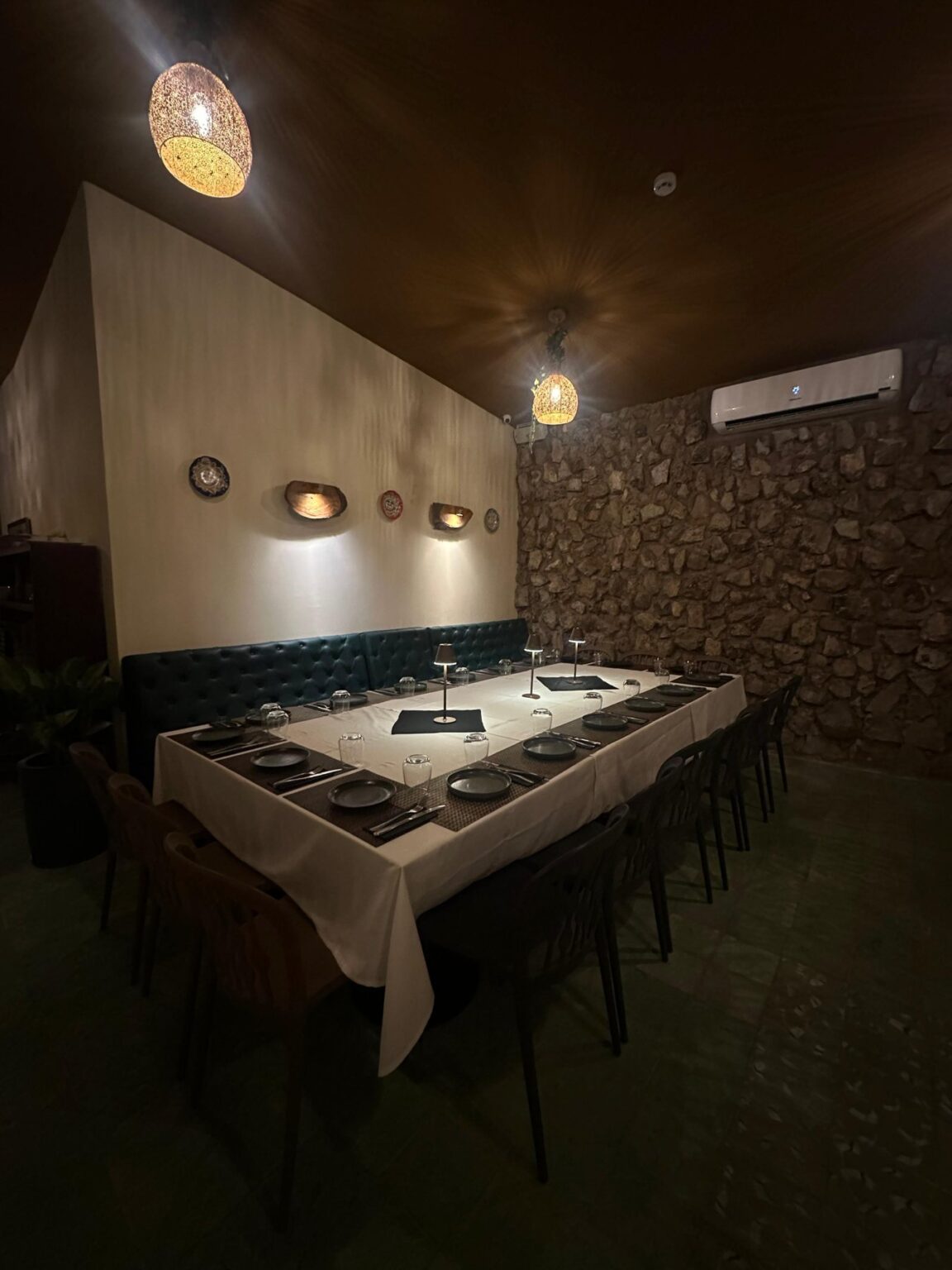 Mesa para grupo junto a la pared de piedra en el salón interno de El Origen